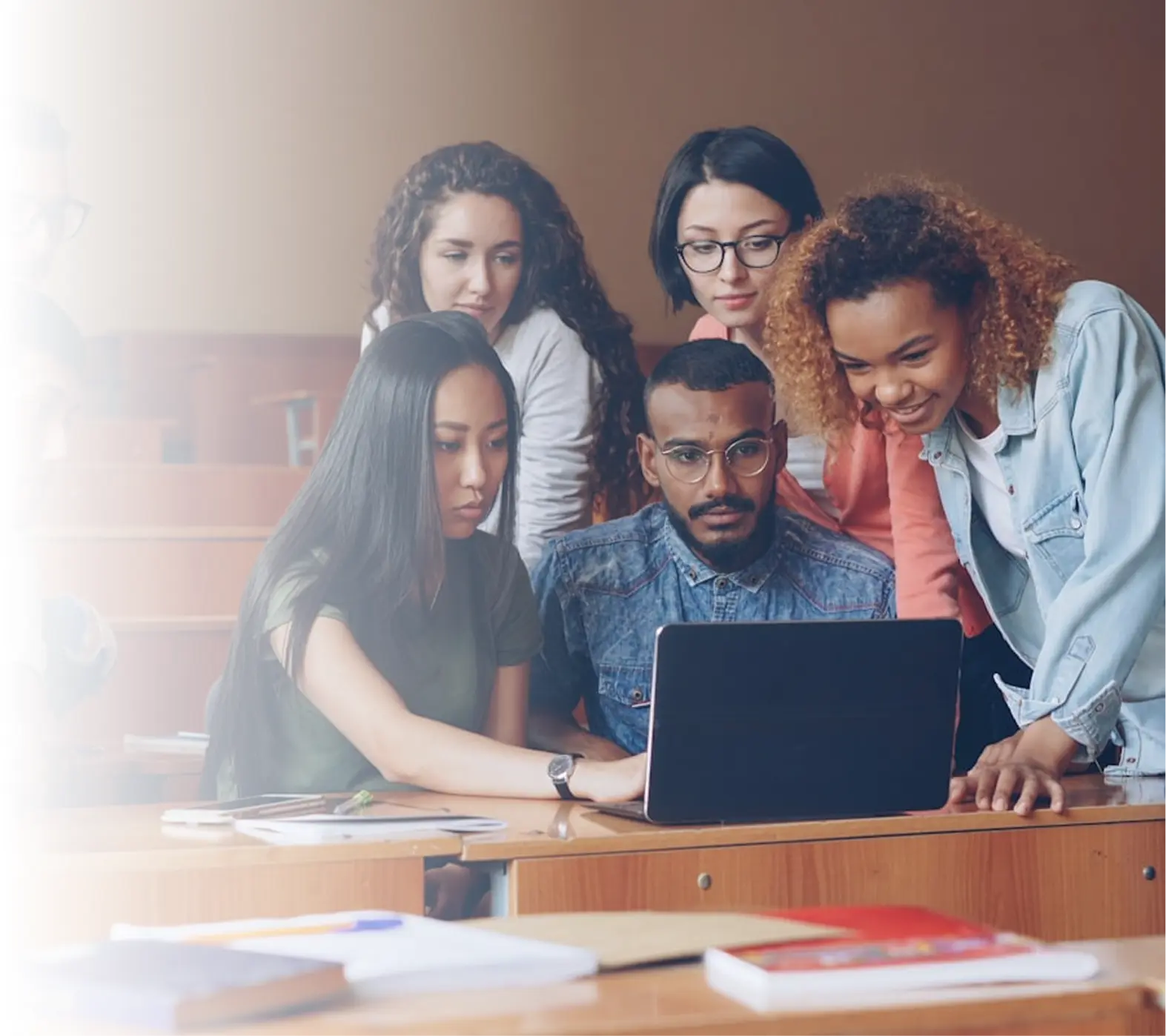 Diverse group of students collaborating around a laptop