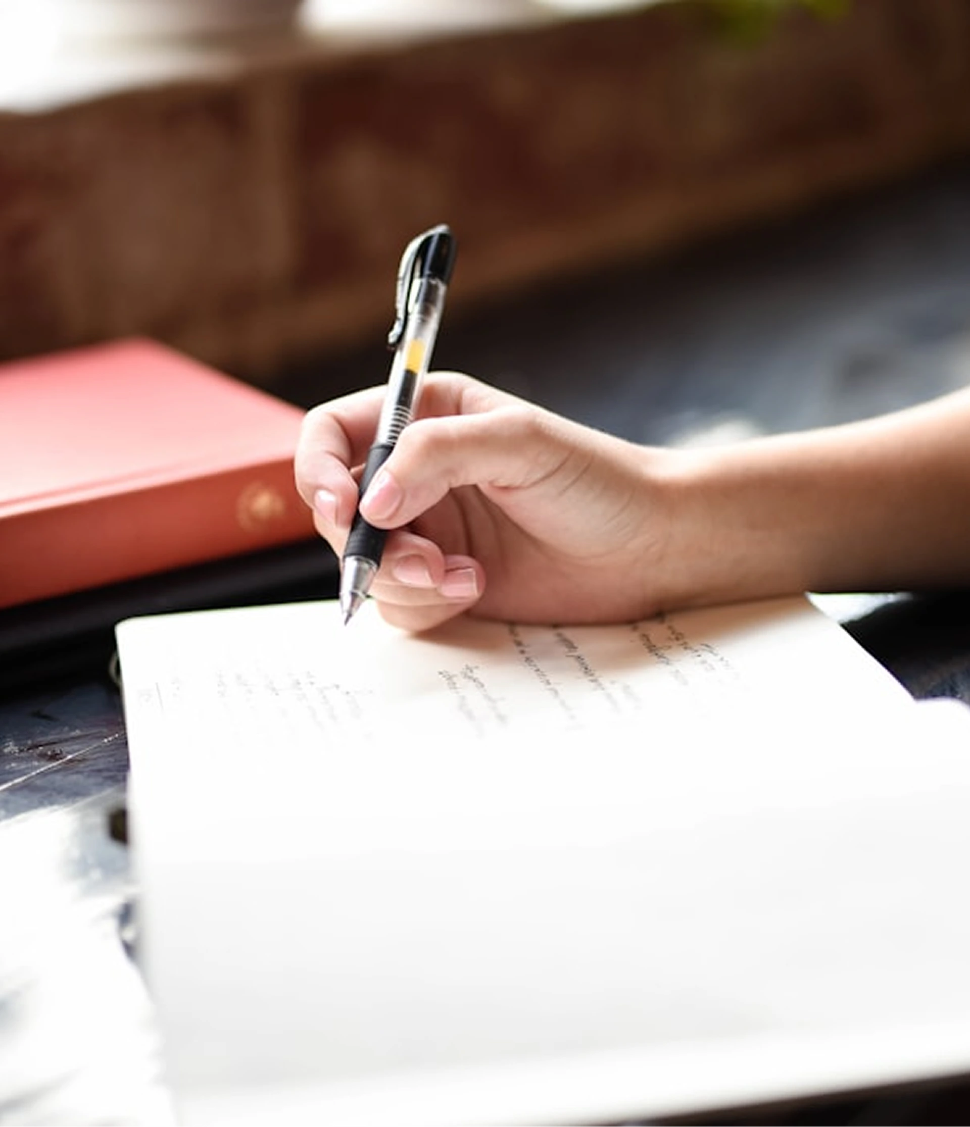 Hand writing in a notebook with a pen